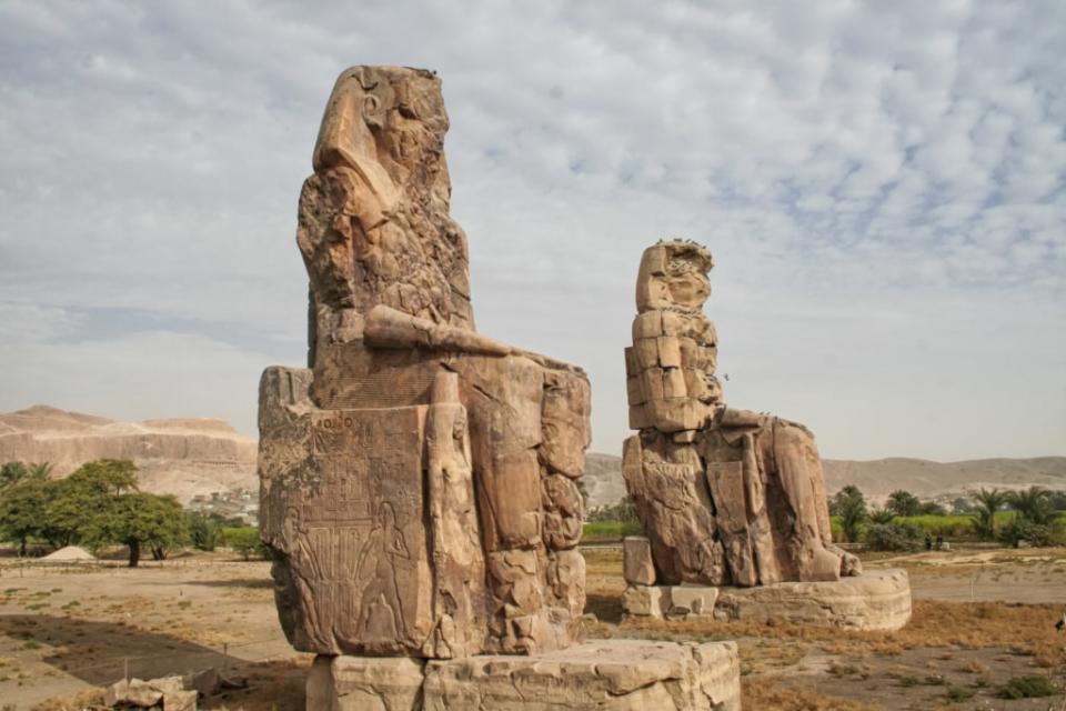 Colossi of Memnon, stone statues of the Pharaoh <span class="caas-xray-inline-tooltip"><span class="caas-xray-inline caas-xray-entity caas-xray-pill rapid-nonanchor-lt" data-entity-id="Amenhotep_III" data-ylk="cid:Amenhotep_III;pos:1;elmt:wiki;sec:pill-inline-entity;elm:pill-inline-text;itc:1;cat:Royalty;" tabindex="0" aria-haspopup="dialog"><a href="https://search.yahoo.com/search?p=Amenhotep%20III" data-i13n="cid:Amenhotep_III;pos:1;elmt:wiki;sec:pill-inline-entity;elm:pill-inline-text;itc:1;cat:Royalty;" tabindex="-1" data-ylk="slk:Amenhotep III;cid:Amenhotep_III;pos:1;elmt:wiki;sec:pill-inline-entity;elm:pill-inline-text;itc:1;cat:Royalty;" class="link ">Amenhotep III</a></span></span> in Egypt. (Photo: Adobe Stock)