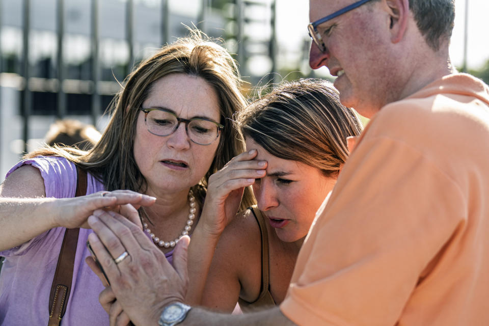 Karmen and Bart Swanson who are waiting for their son caught in a lockdown at the Mall of America share a video of the shooting with a fellow shopper in Bloomington, Minn., on Thursday, Aug. 4, 2022. Police in Minnesota confirm that gunshots were fired at the Mall of America in suburban Minneapolis, but say no victim has been found. (Richard Tsong-Taatarii/Star Tribune via AP)