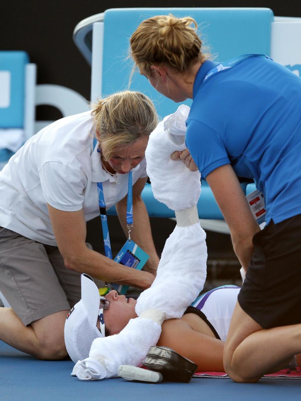 Yaroslava Shvedova of Kazakhstan receives treatment by trainers during her first round match against Sloane Stephens of the U.S. at the Australian Open tennis championship in Melbourne, Australia, Tuesday, Jan. 14, 2014.(AP Photo/Aaron Favila)