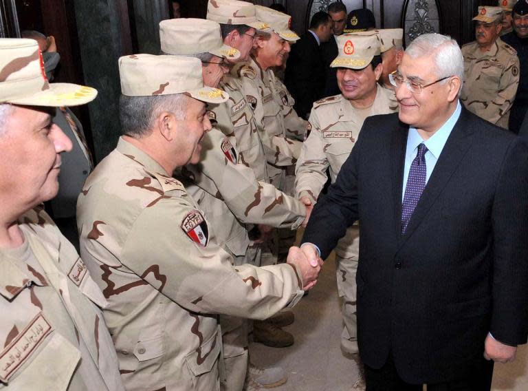 A photo released by the Egyptian presidency shows interim president Adly Mansour (R) and Defense Minister Abdel-Fattah al-Sisi (2R) shaking hands with members of the Supreme Council of the Armed Forces (SCAF) in Cairo on March 26, 2014