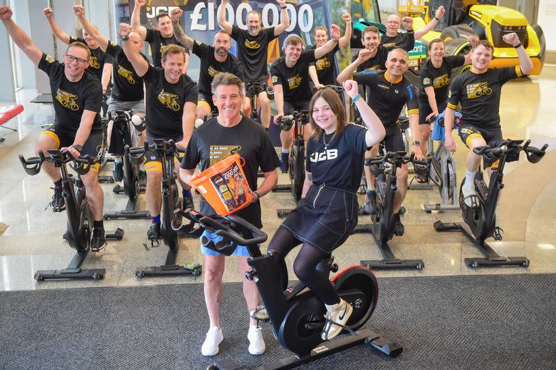 Hannah Roberts pictured with Lord Coe and members of the JCB Around The World in 80 Days cycling team. -Credit:JCB