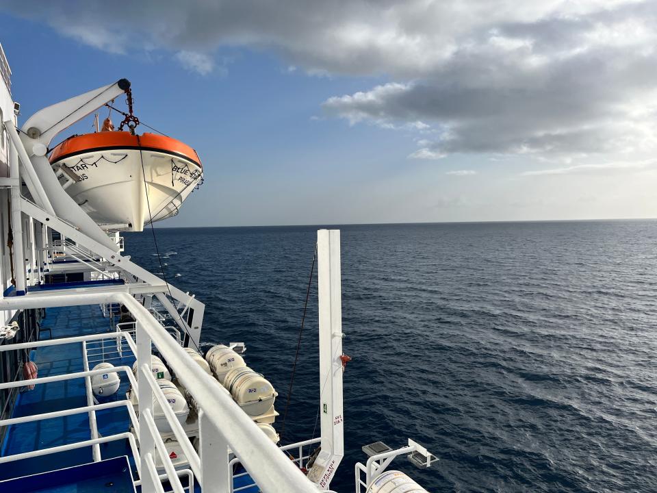 view of a big ferry on the water from the perspective of someone standing on the back deck