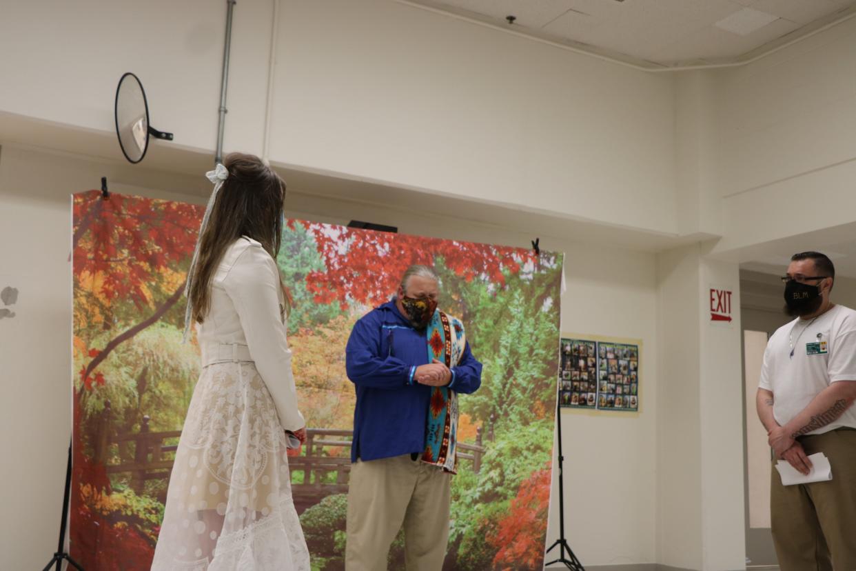 The author and her husband at their wedding in the prison visit room with their chaplain Brian Henry.  (Photo: Courtesy of Chelsea Moore)