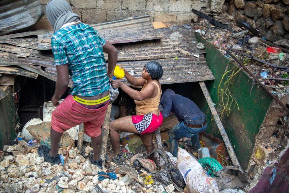 Residents look for salvage items next to the Tet Dlo river after the passing of Tropical Storm Laura in Port-au-Prince, Haiti, Sunday, Aug. 23, 2020.