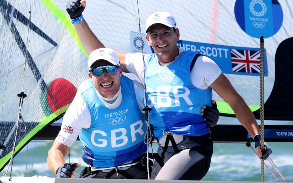 Dylan Fletcher and Stuart Bithell of Team Great Britain celebrate as they win gold in the Men's Skiff 49er class on day eleven of the Tokyo 2020 Olympic Games at Enoshima Yacht Harbour