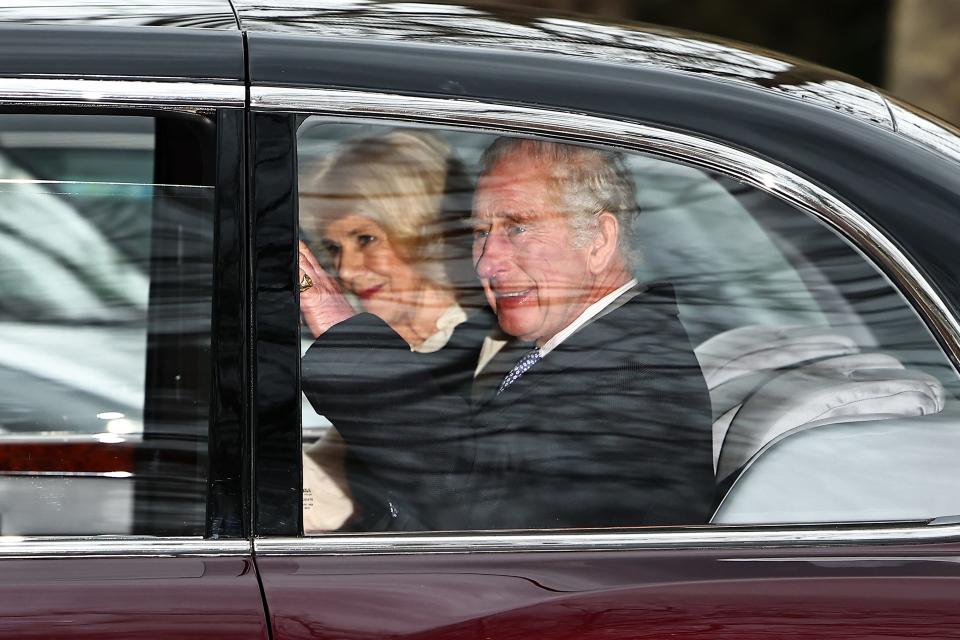 Britain's King Charles III and Britain's Queen Camilla wave as they leave by car from Clarence House, travelling to Buckingham Palace, in London on February 6, 2024.