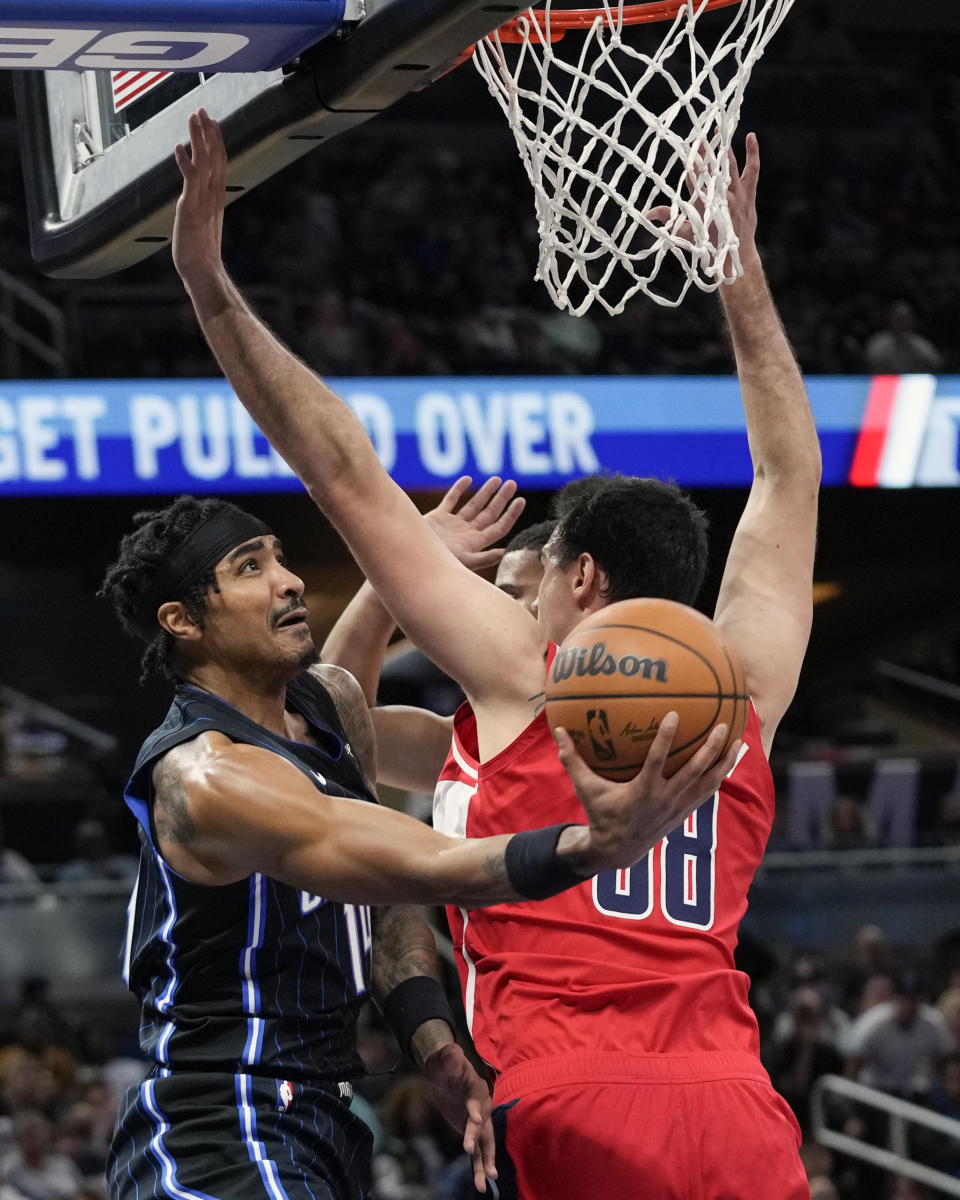 Orlando Magic guard Gary Harris, left, shoots from behind the back of Washington Wizards forward Danilo Gallinari (88) during the first half of an NBA basketball game Friday, Dec. 1, 2023, in Orlando, Fla. (AP Photo/John Raoux)