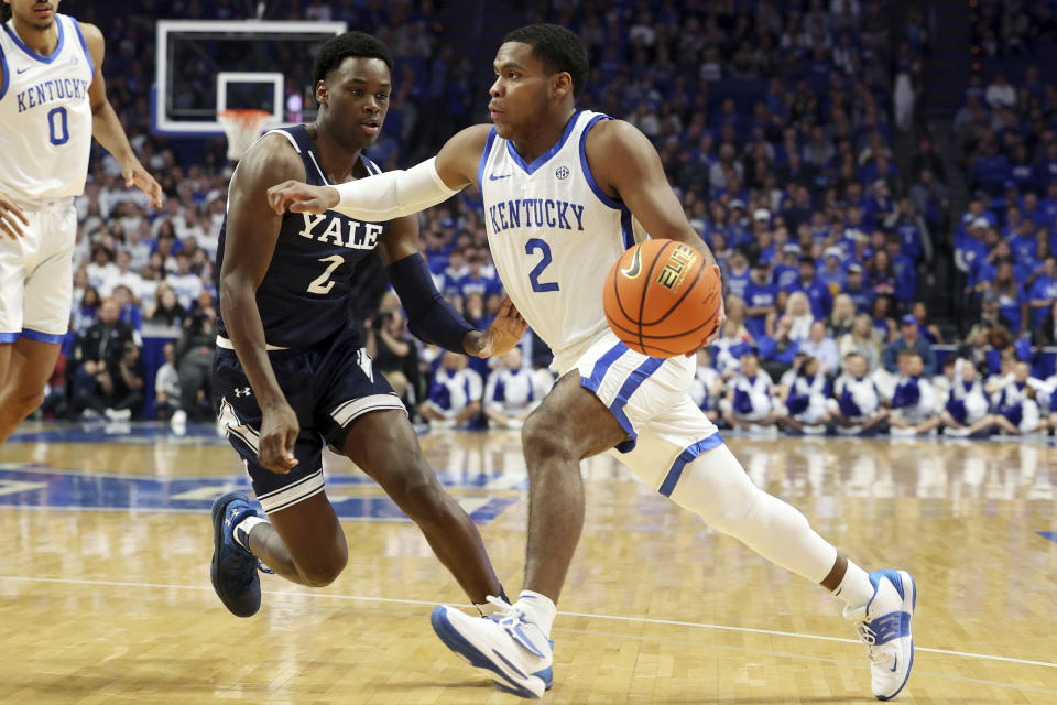 Kentucky's Sahvir Wheeler, right, drives on Yale's Bez Mbeng during the first half of an NCAA college basketball game in Lexington, Ky., Saturday, Dec. 10, 2022. (AP Photo/James Crisp)