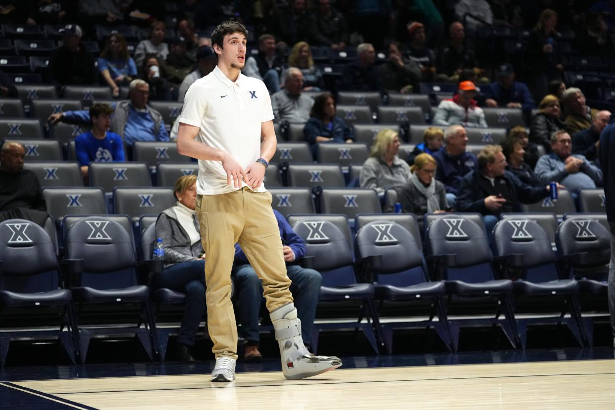 Xavier Musketeers forward Zach Freemantle (32), seen wearing a walking boot, assists during warm ups before a college basketball game between the Providence Friars and the Xavier Musketeers, Wednesday, Feb. 1, 2023, at Cintas Center in Cincinnati. 