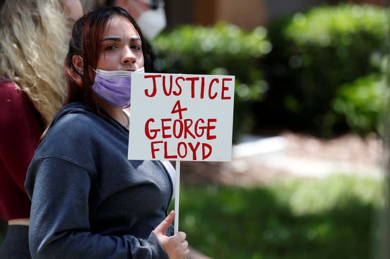 FILE PHOTO: A protester holds a sign outside the Florida home of former Minneapolis police officer Derek Chauvin, in Orlando
