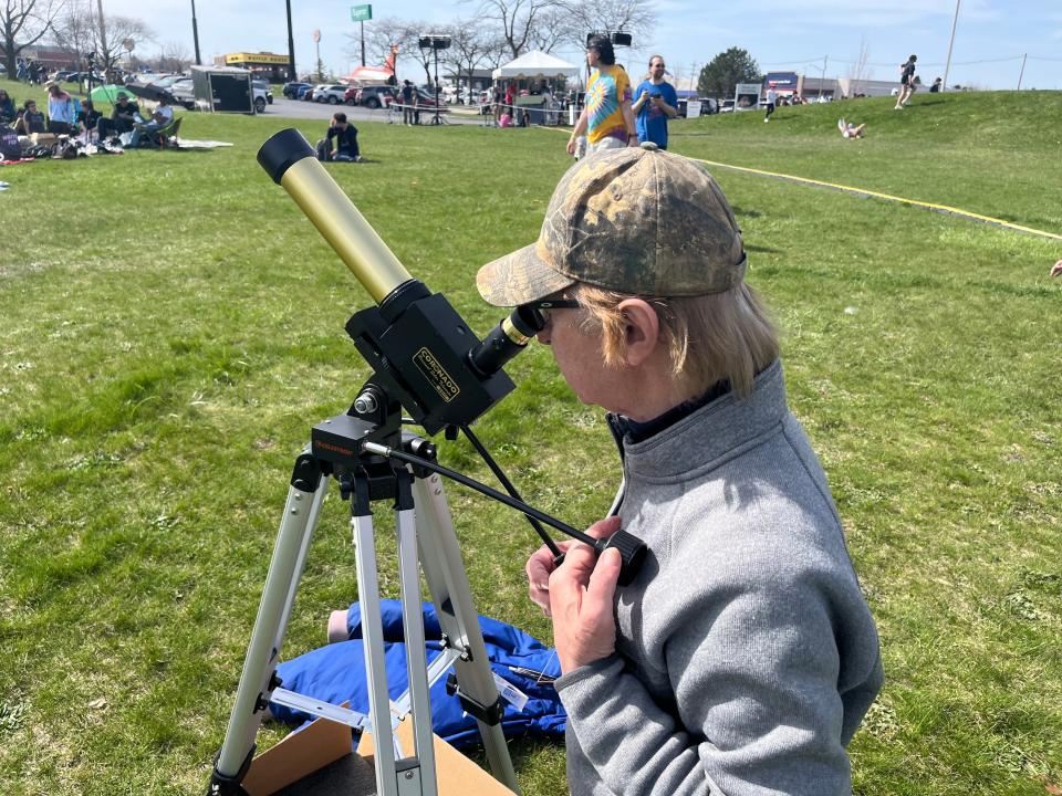 Michael Latke, an astronomy enthusiast who helped engineer parts for moon rockets, looks at the eclipse through his telescope at Armstrong Air & Space Museum in Wapakoneta on April 8, 2024.