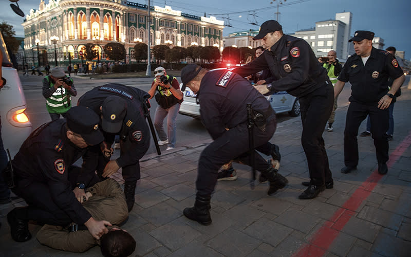 Police detain demonstrators during a protest in Russia