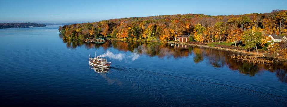 Autumn visitors to Lake Geneva get million dollar views on a double decker boat cruise, with old growth trees and historic mansions rimming the shoreline.