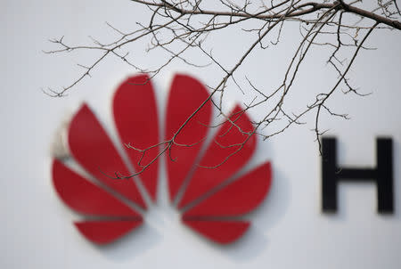 FILE PHOTO: A Huawei company logo is seen behind tree branches in Beijing, China March 2, 2019. Picture taken March 2, 2019. REUTERS/Jason Lee