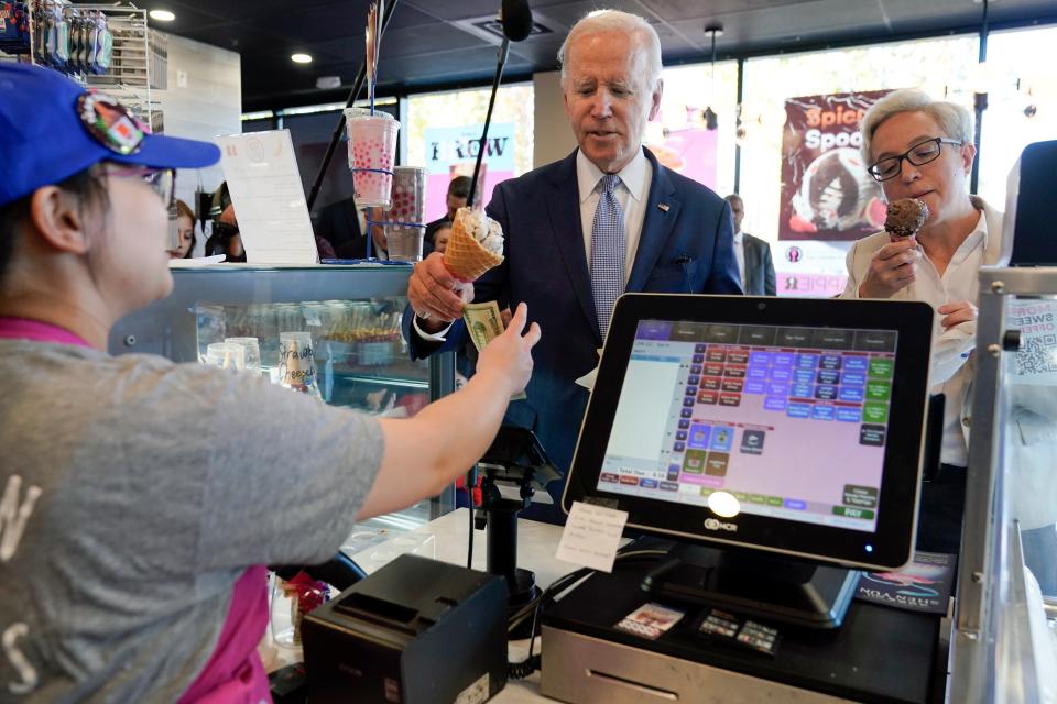 President Joe Biden pays for ice cream with Tina Kotek, the Oregon Democratic nominee for governor, in Portland on Oct. 15, 2022.