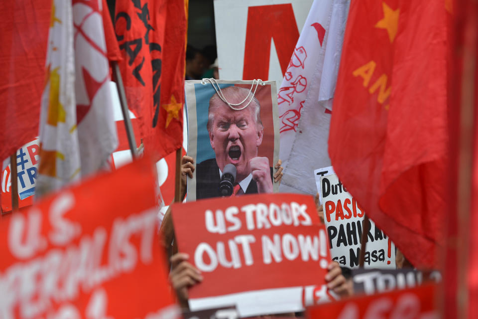 <p>Protesters display anti-US President Donald Trump placards along with his portrait during a rally near the U.S. Embassy, ahead of the 31st Southeast Asian Nations (ASEAN) Summit, in Manila on Nov. 10, 2017. (Photo: Ted Aljibe/AFP/Getty Images) </p>