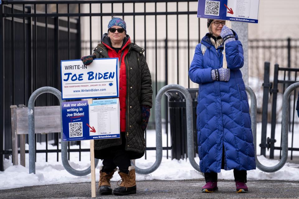 Liz-Anne Platt (left), 66, and Maura Willing (center), 62, ask voters to write in President Joe Biden outside the Christa McCauliffe Elementary School in Concord, NH, as voters cast ballots in the New Hampshire presidential primary on January 23, 2024.