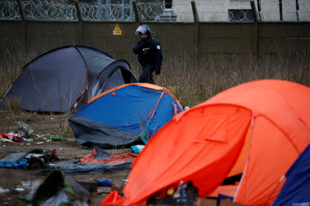 A French police officer walks past empty tents during the dismantling of a camp used by migrants in Calais, France, January 10, 2019. Picture taken January 10, 2019. REUTERS/Pascal Rossignol