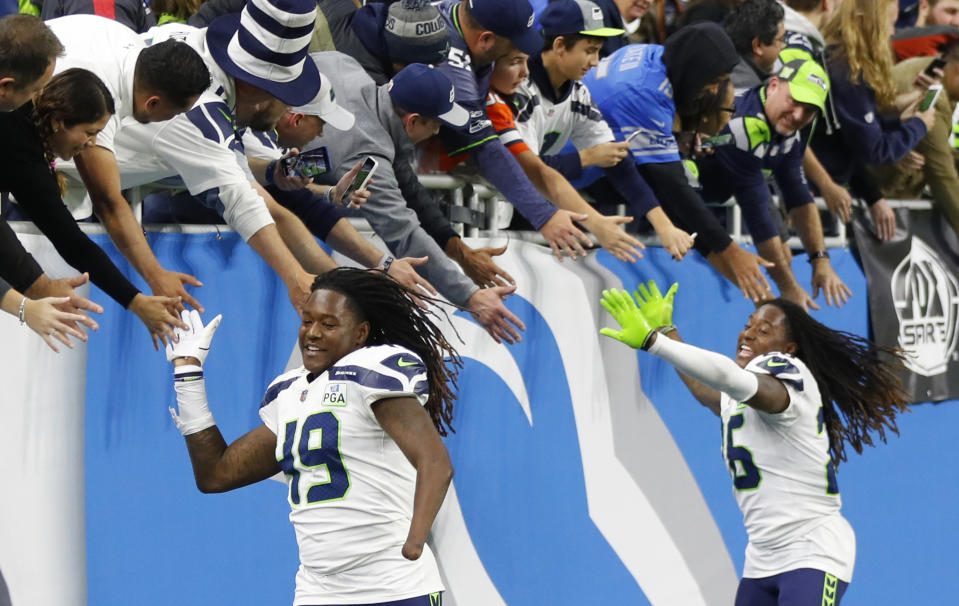 FILE - In this Sunday, Oct. 28, 2018, file photo, Seattle Seahawks linebacker Shaquem Griffin (49) and cornerback Shaquill Griffin (26) shake hands with fans after an NFL football game against the Detroit Lions in Detroit. The NFL is partnering with three non-profit, non-partisan organizations to get out the vote as the league leverages its “Inspire Change” initiative. The program will support and encourage voting and civic engagement efforts of current and former NFL players, club and league personnel and fans beginning Friday, Aug. 7, 2020, until Election Day in November. The Griffins are at the forefront of the movement among players. (AP Photo/Paul Sancya, File)