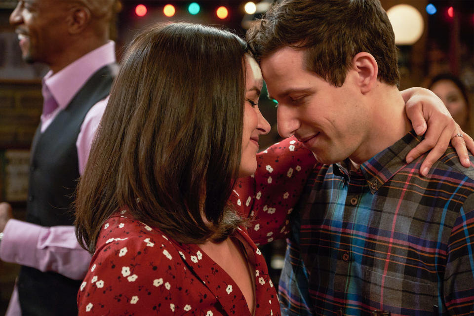 Melissa Fumero embraces Andy Samberg while dancing at a party