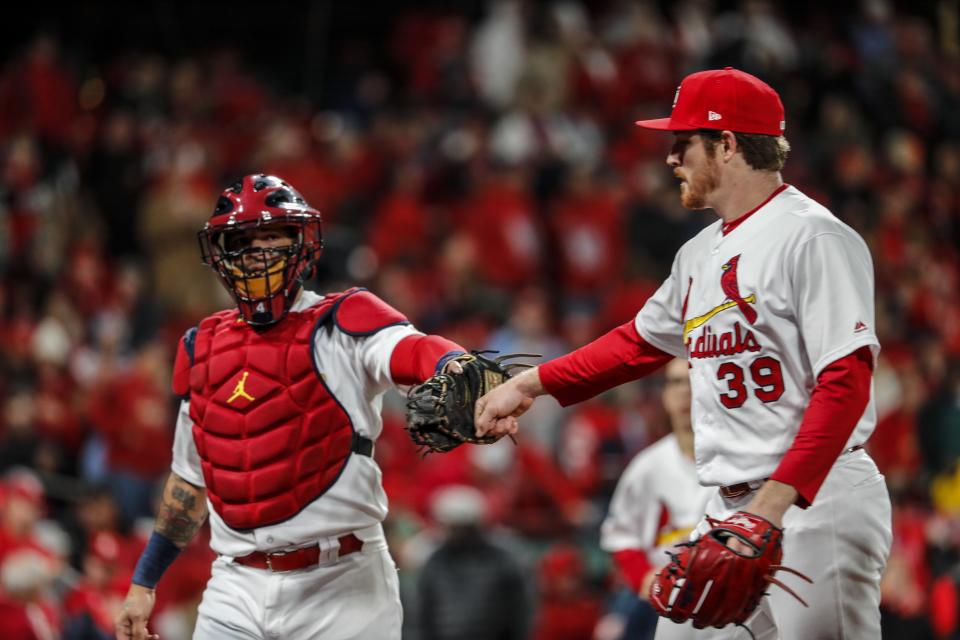 St. Louis Cardinals starting pitcher Miles Mikolas is congratulated by catcher Yadier Molina after the first inning of Game 1 of the National League Championship Series baseball game against the Washington Nationals Friday, Oct. 11, 2019, in St. Louis. (AP Photo/Jeff Roberson)