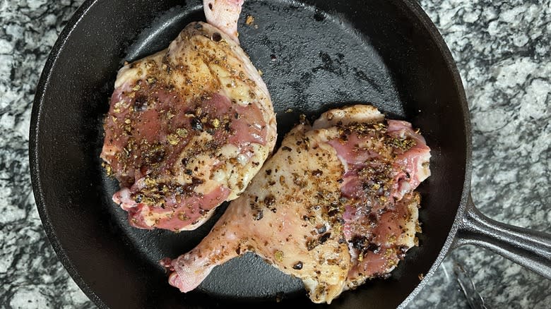 seasoned duck thighs in pan