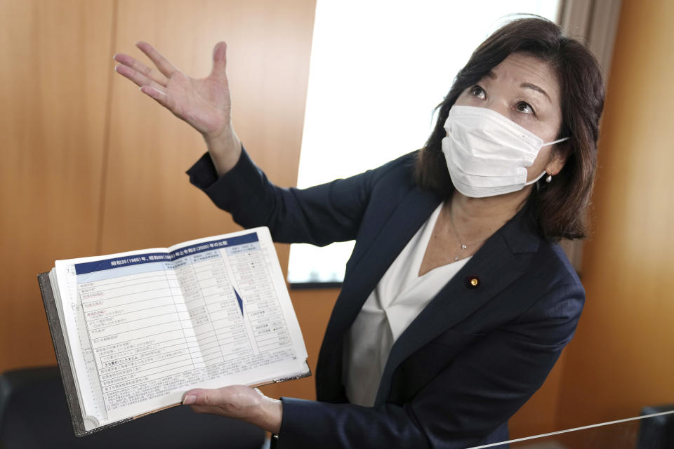 Japanese Gender Equality Minister Seiko Noda shows information on situation in 1955 and 2020 during an interview with The Associated Press Tuesday, July 26, 2022, in Tokyo. Noda called the country’s record low births and plunging population a national crisis and blamed "indifference and ignorance" in the male-dominated Japanese parliament for the neglect. (AP Photo/Eugene Hoshiko)