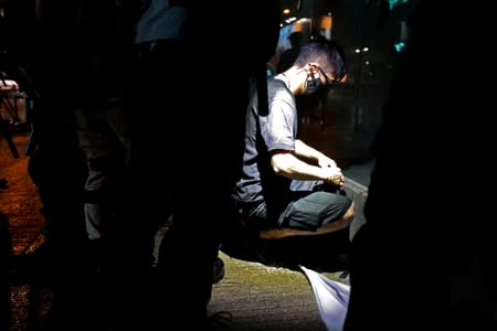 A masked man sits during an anti-government rally in Hong Kong