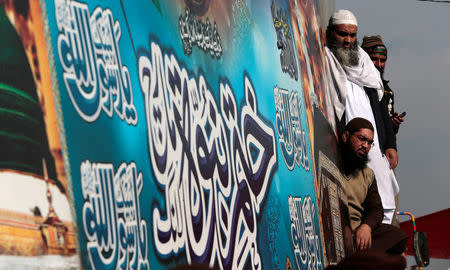 Supporters of the Tehrik-e-Labaik Pakistan Islamist political party listen to their leader Khadim Hussain Rizvi (not pictured) as he speaks with the media at their protest site at Faizabad junction in Islamabad, Pakistan November 27, 2017. REUTERS/Caren Firouz