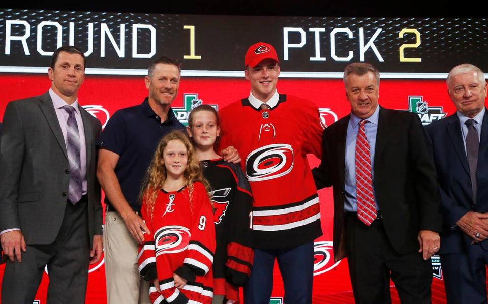 Andrei Svechnikov, center, of Russia, poses after being selected by the Carolina Hurricanes during the NHL hockey draft in Dallas, Friday, June 22, 2018.