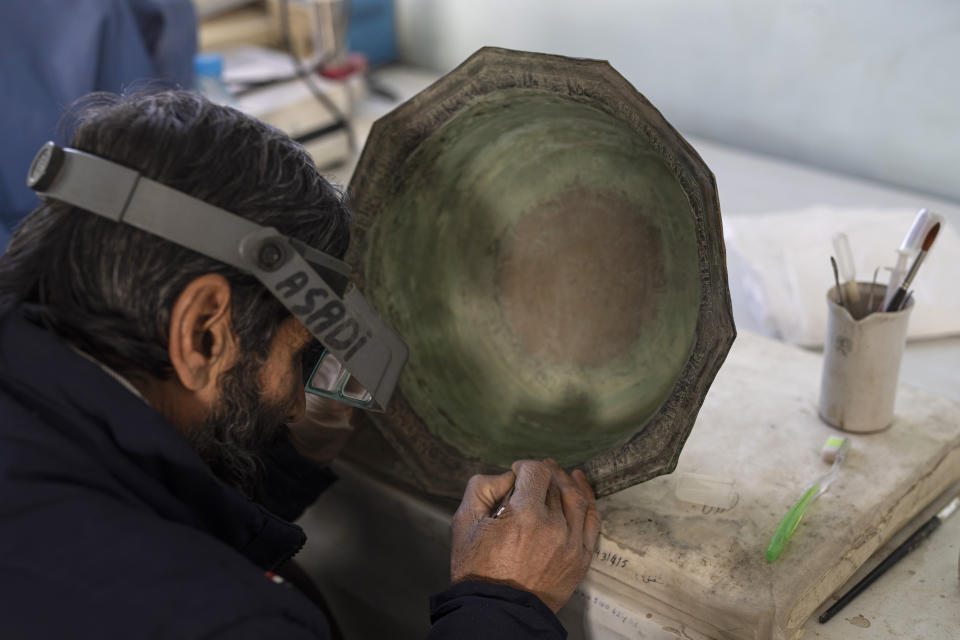 Conservator Mohammad Name Noorzai works at The National Museum of Afghanistan, in Kabul, Monday, Dec. 6, 2021. The National Museum of Afghanistan is open once again -- and the Taliban, whose members once smashed their way through the facility, destroying irreplaceable pieces of Afghanistan's national heritage, now appear to be among its most enthusiastic visitors. (AP Photo/Petros Giannakouris)