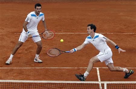 Britain's Andy Murray (R) returns a ball as his teammate Colin Fleming looks on during their Davis Cup quarter-final doubles tennis match against Italy's Fabio Fognini and Simone Bolelli in Naples April 5, 2014. REUTERS/Alessandro Bianchi