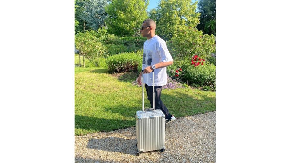 man walking with silver suitcase