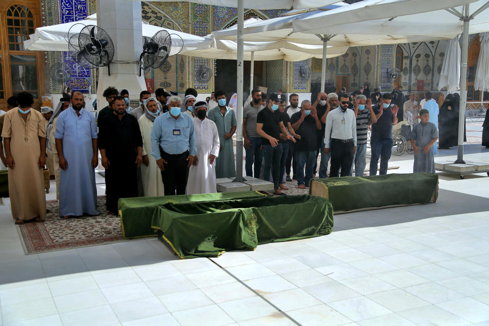 Mourners prepare to bury hospital fire victims in Najaf, Iraq, Tuesday, July 13, 2021. A catastrophic blaze erupted at a coronavirus hospital ward in southern Iraq of Nasiriyah on Monday. It was the second time a large fire killed coronavirus patients in an Iraqi hospital this year. (AP Photo/Anmar Khalil)