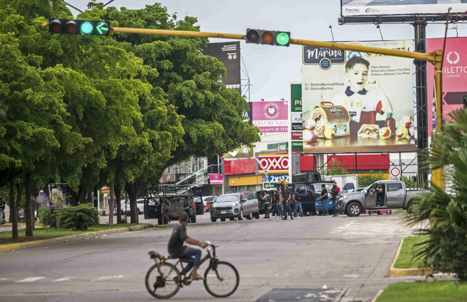 Unidentified gunmen block a street in Culiacan, Mexico, Thursday, Oct. 17, 2019. An intense gunfight with heavy weapons and burning vehicles blocking roads raged in the capital of Mexico’s Sinaloa state Thursday after security forces located one of Joaquín “El Chapo” Guzmán’s sons who is wanted in the U.S. on drug trafficking charges. (AP Photo/Augusto Zurita)