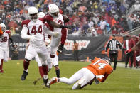 Arizona Cardinals safety Budda Baker (3) leaps over Chicago Bears quarterback Andy Dalton after Baker intercepted a Dalton pass during the first half of an NFL football game Sunday, Dec. 5, 2021, in Chicago. Running with Baker is Markus Golden. (AP Photo/David Banks)