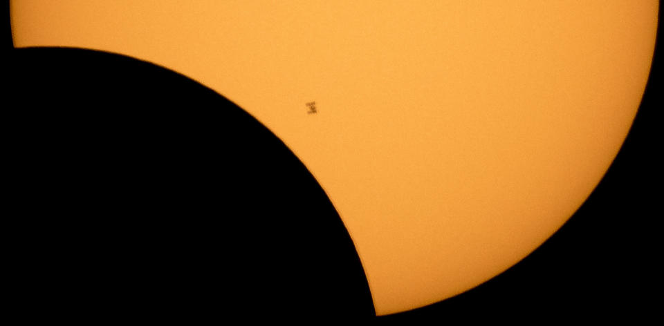 FILE - In this image made available by NASA, the International Space Station is silhouetted against the sun during a solar eclipse Monday, Aug. 21, 2017, as seen from Ross Lake, Northern Cascades National Park in Washington state. Full solar eclipses occur every year or two or three, often in the middle of nowhere like the South Pacific or Antarctic. The next total solar eclipse, in 2026, will grace the northern fringes of Greenland, Iceland and Spain. (Bill Ingalls/NASA via AP, File)