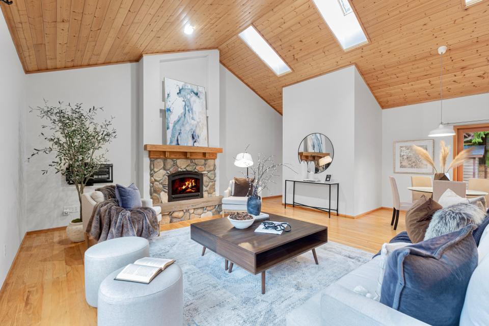 a living room in the home where Jeff Bezos started Amazon, including a coffee table, skylights, furniture, and fireplace