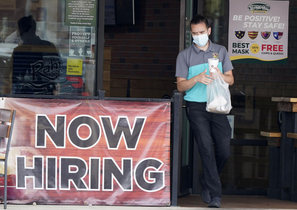 FILE - In this Sept. 2, 2020 file photo, a customer wears a face mask as they carry their order past a now hiring sign at an eatery in Richardson, Texas. On Thursday, Nov. 5, the number of Americans seeking unemployment benefits fell slightly last week to 751,000, a still-historically high level that shows that many employers keep cutting jobs in the face of the accelerating pandemic. (AP Photo/LM Otero, File)