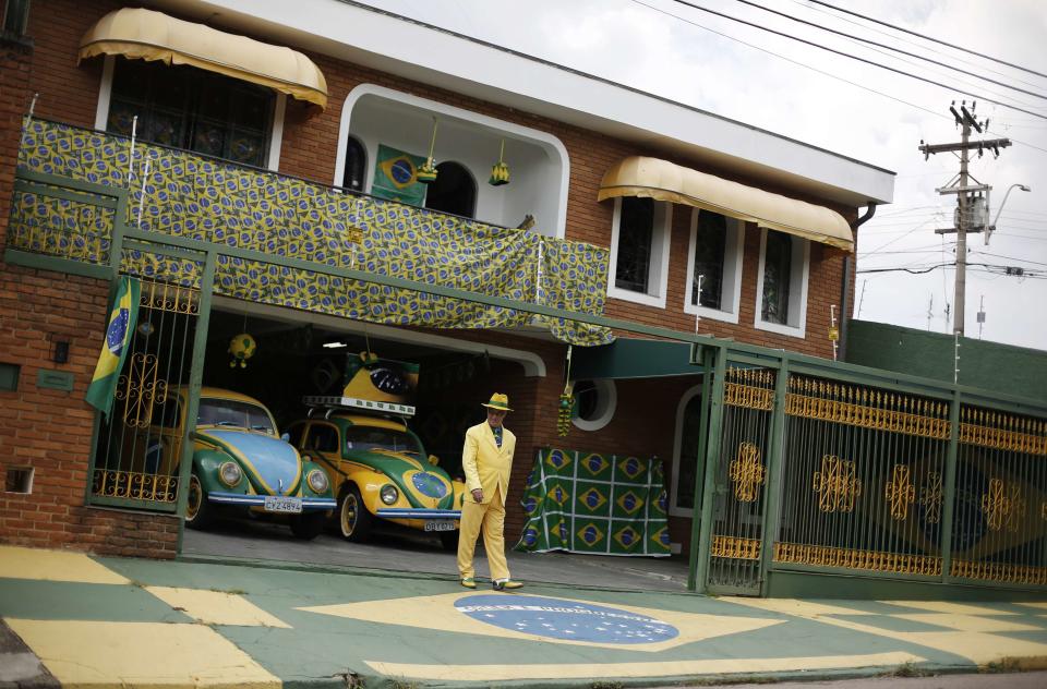 Brazilian attorney, Nelson Paviotti, stands outside his home decorated with the colors of the national flag in Campinas