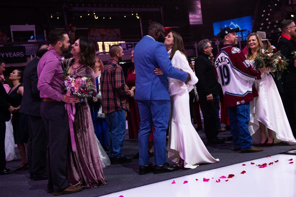Couples kiss after saying their vows at a group wedding ceremony on the ice at the Budweiser Events Center on Feb. 14, 2023, in Loveland. Twelve couples got married during the Valentine's Day event, with more renewing their vows.