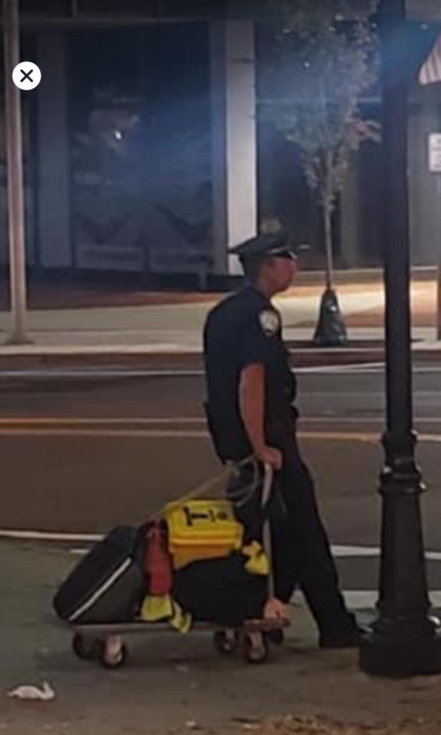 Morristown police officer Keith Hudson is seen pulling a cart with emergency equipment during a late-night walking post. The photo is cited in the PBA lawsuit filed on Monday.