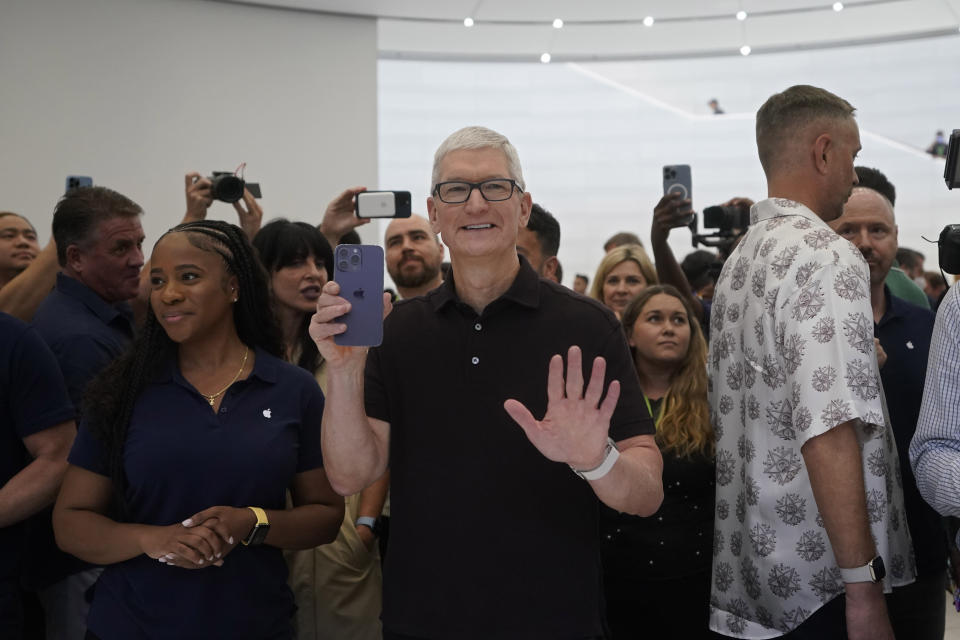 Generálny riaditeľ spoločnosti Apple Tim Cook zdvíha iPhone 14 Pro na podujatí Apple v areáli sídla spoločnosti Apple v Cupertine v Kalifornii, v stredu 7. septembra 2022. (AP Photo/Jeff Chiu)