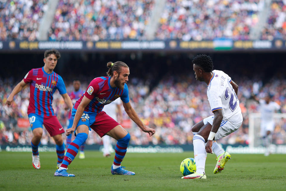 BARCELONA, SPAIN - OCTOBER 24: Vinicius Junior of Real Madrid dribbles Oscar Mingueza of FC Barcelona during the LaLiga Santander match between FC Barcelona and Real Madrid CF at Camp Nou on October 24, 2021 in Barcelona, Spain. (Photo by Eric Alonso/Getty Images)