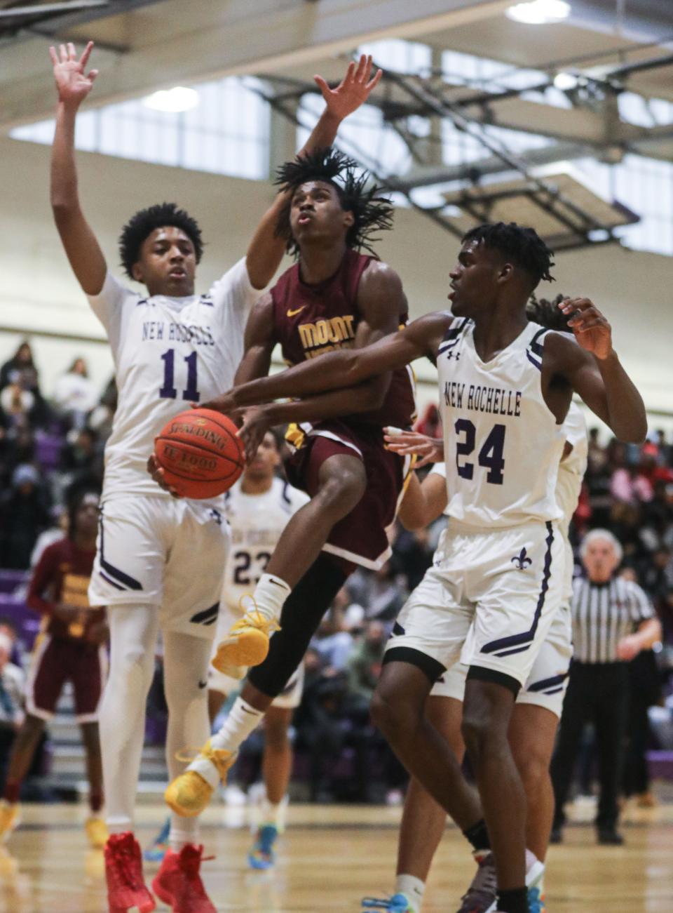 Dylan Colon of Mount Vernon drives between Malik Gasper and Darrin Greaves II Sr. of New Rochelle during a varsity basketball game at New Rochelle High School Feb. 7, 2023. Mount Vernon defeated New Rochelle 66-56.
