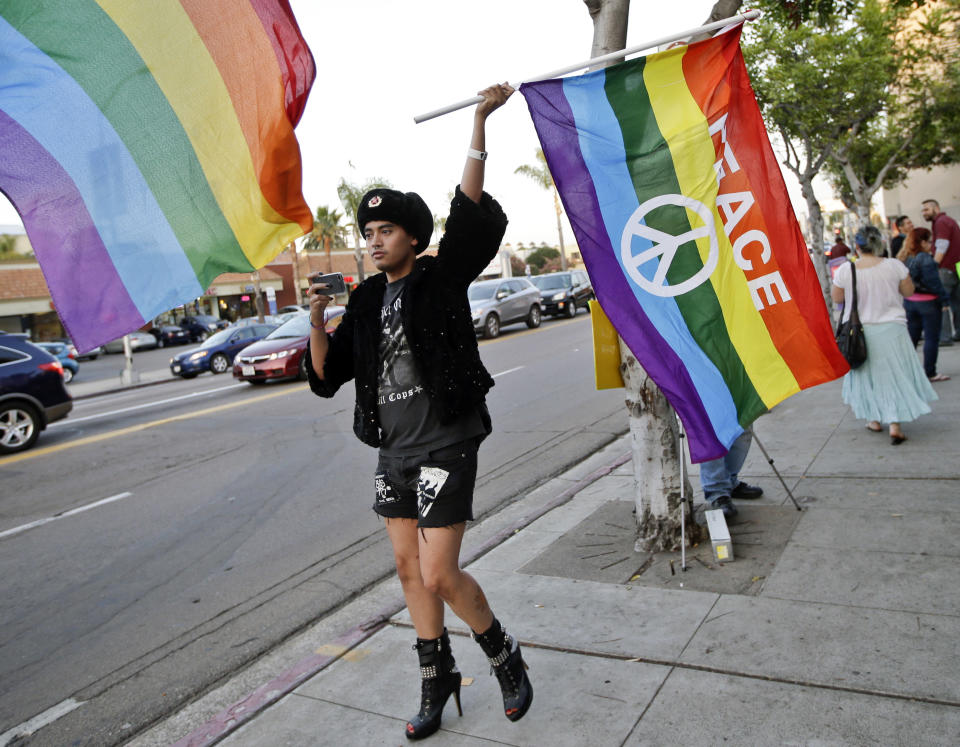 Bryan Kimpton, a supporter of the School Success and Opportunity Act (AB1266) waves a flag while celebrating at a rally organized by San Diego LGBTQ rights organizations Canvass for a Cause, SAME Alliance, and Black and Pink after a petition drive to place a proposition on the ballot to repeal the law failed to garner enough signatures Monday, Feb. 24, 2014, in San Diego. (AP Photo/Lenny Ignelzi)