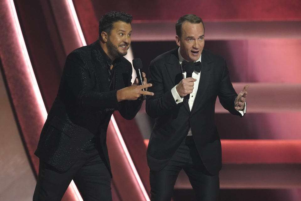 Hosts Luke Bryan, left, and Peyton Manning speak at the 57th Annual CMA Awards on Wednesday, Nov. 8, 2023, at the Bridgestone Arena in Nashville, Tenn. (AP Photo/George Walker IV)