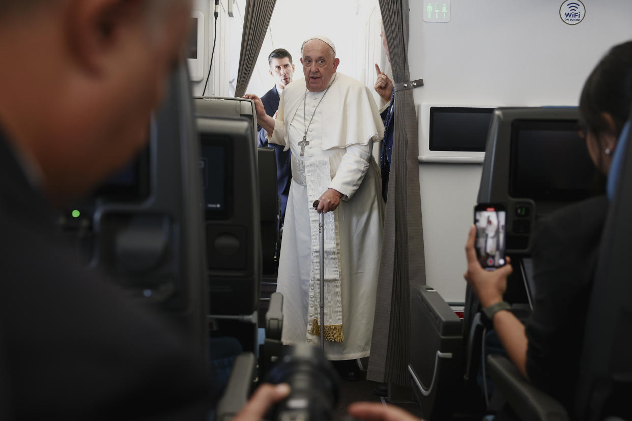 Pope Francis attends a news conference aboard the papal plane on his flight back after his 12-day journey across Southeast Asia and Oceania, Friday, Sept. 13, 2024. (Guglielmo Mangiapane/Pool Photo via AP)