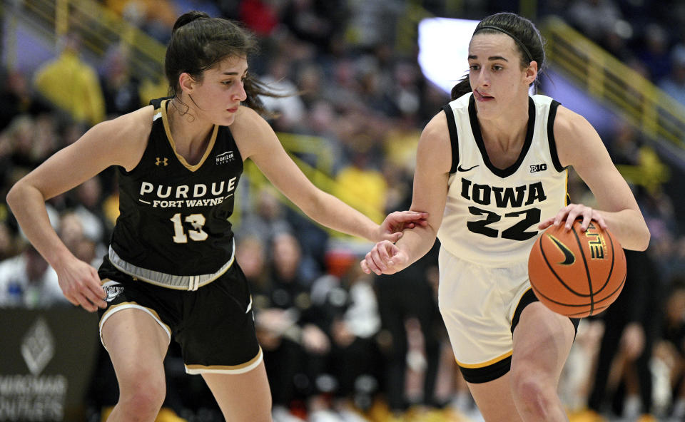 Iowa's Caitlin Clark (22) tries to get around Purdue Fort Wayne defender Amellia Bromenschenkel (13) during the first half of an NCAA college basketball game, Friday, Nov. 24, 2023, in Estero, Fla. (AP Photo/Chris Tilley)