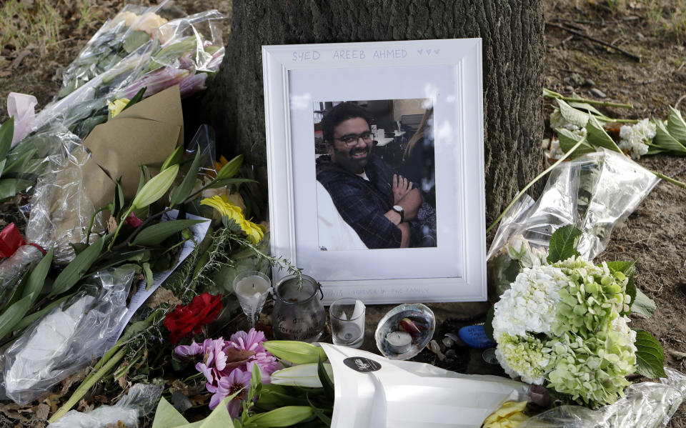 A photo tribute for Christchurch mosque shooting victim Syed Areeb Ahmed, 26, lies amid mounds of flowers in Christchurch, New Zealand on Tuesday, March 19, 2019. Ahmed's uncle described the Pakistani native as a bright accountant just starting his career who always put education first. (AP Photo/Mark Baker)